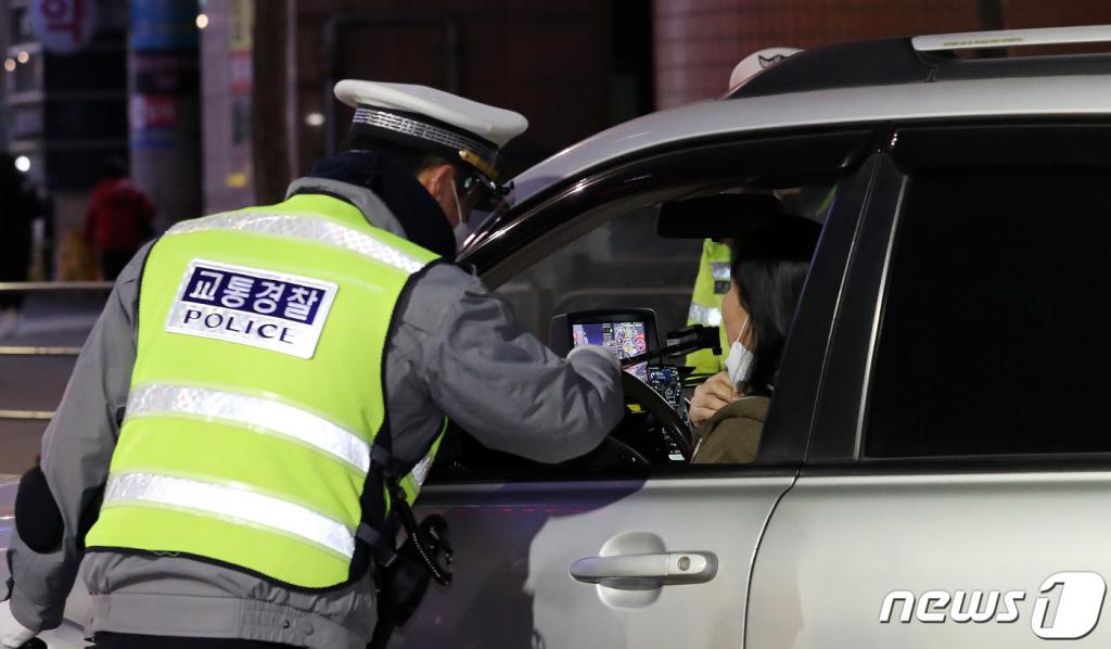 (서울=뉴스1) 박지혜 기자 = 강남경찰서 관계자들이 23일 오후 서울 신사역사거리에서 비접촉식 감지기로 음주단속을 실시하고 있다.  정부의 거리두기 조치 완화로 오후 10시로 늦춰진 음식점 등의 영업종료 시간이 집중단속 시간이다. 방역단계가 완화된 시기에 음주운전 사고가 늘어났던 것에 따른 조치다. 2021.2.23/뉴스1