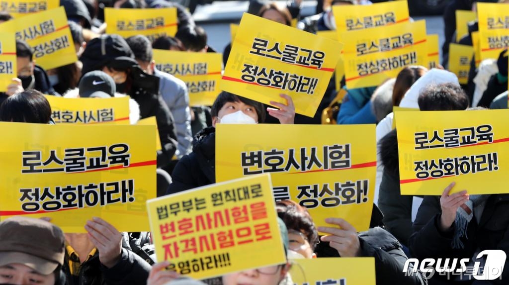 (서울=뉴스1) 박지혜 기자 = 법학전문대학원(로스쿨) 재학생과 졸업생들이 18일 오후 청와대 사랑채 인근 정부서울청사 창성동별관 옆에서 열린 ‘어게인 218, 로스쿨개혁이 사법개혁이다’ 궐기대회에서 변호사 시험의 자격시험화를 외치고 있다. 이들이 도서관 대신 거리로 나선 이유는 로스쿨과 변호사시험이 각각 도입 취지와 달리 정원제로 운영되고 있어 심각한 부작용을 일으키고 있다는 문제의식 때문이다. 응시인원이 아닌 입학정원이라는 고정된 인원을 기준으로 합격자를 배출한 결과 매년 누적적으로 탈락자가 발생하면서 변호사시험 합격률은 급격히 하락하고 있다. 2020.2.18/뉴스1