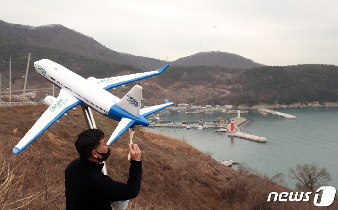 4일 오전 부산 강서구 대항동 대항전망대에서 한 페인트 작업자가 비행기 모형에 적힌 신공항 건설 반대 문구를 지우는 페인트 작업을 하고 있다. 가덕도 신공항을 찬성하기 위해 설치한 이 비행기 조형물에는 'No Plane No Pain(비행기가 없으면 고통도 없다), '우리는 살고싶다'등 신공항 건설 반대 문구가 쓰여 있었다. 2021.3.4 /뉴스1 © News1 여주연 기자