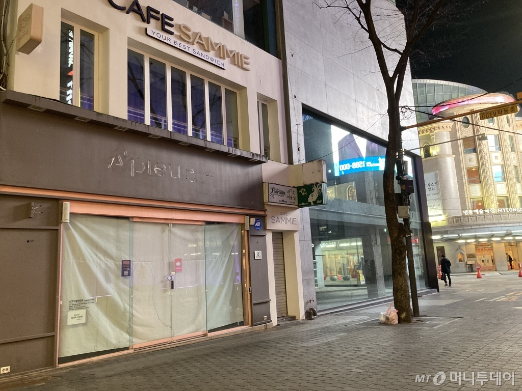 지난 4일 오후 명동의 폐업한 한 화장품 가게 뒤로 행인이 지나가고 있다. /사진=김소영 기자