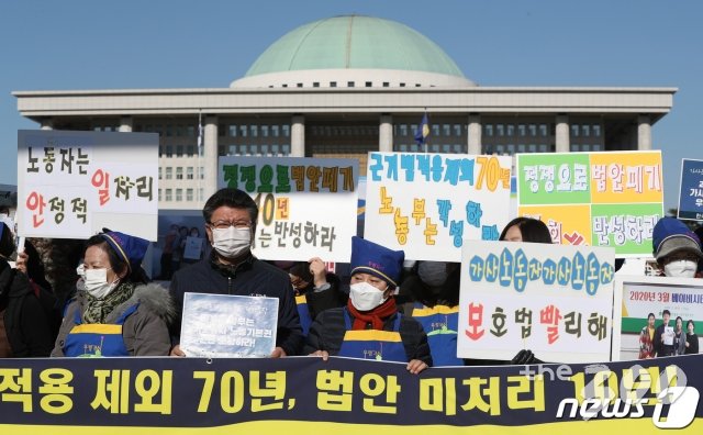 (서울=뉴스1) 민경석 기자 = 한국가사노동자협회 조합원들이 4일 오전 서울 영등포구 여의도 국회의사당 앞에서 열린 '가사노동자 고용개선에 관한 법 통과 촉구 기자회견'에서 구호를 외치고 있다.  이날 참가자들은 '근로기준법 제정 이후 70여년 동안 가사노동자들은 '근로기준법 11조 가사사용인 제외' 조항으로 인해 법의 보호를 전혀 받지 못하고 있다'면서 '국회 환노위는 가사근로자 고용개선법을 즉각 처리하라'고 주장했다. 2020.11.4/뉴스1