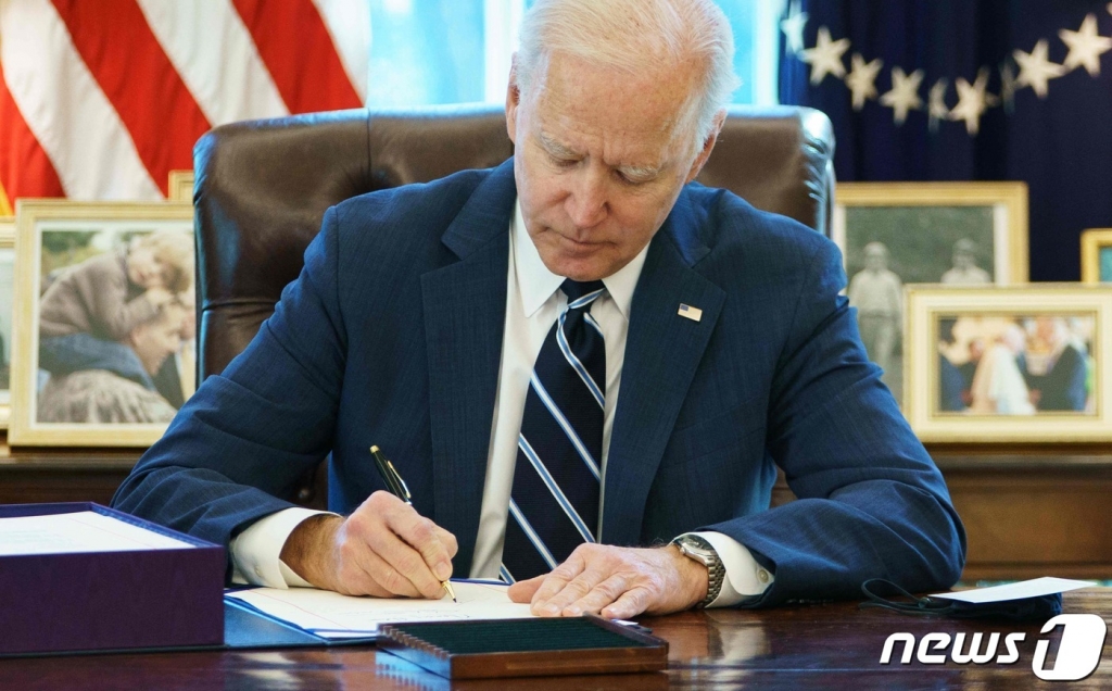 (워싱턴 AFP=뉴스1) 우동명 기자 = 조 바이든 미국 대통령이 11일 (현지시간) 워싱턴 백악관에서 1조9000억달러 규모의 초대형 경기부양 법안을 예정보다 하루 앞당겨 서명을 하고 있다. ? AFP=뉴스1