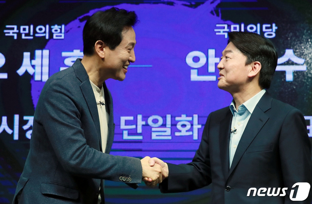 (서울=뉴스1) 국회사진취재단 = 안철수 국민의당 서울시장 후보가 19일 오전 긴급회견을 갖고 국민의힘 김종인·오세훈 단일화방식을 전격 수용하기로 결정했다. 사진은 오 후보(왼쪽)와 안 후보가 지난 15일 서울 영등포 더플러스 스튜디오에서 열린 단일화 비전발표회를 마친 후 악수하고 있는 모습. 2021.3.19/뉴스1