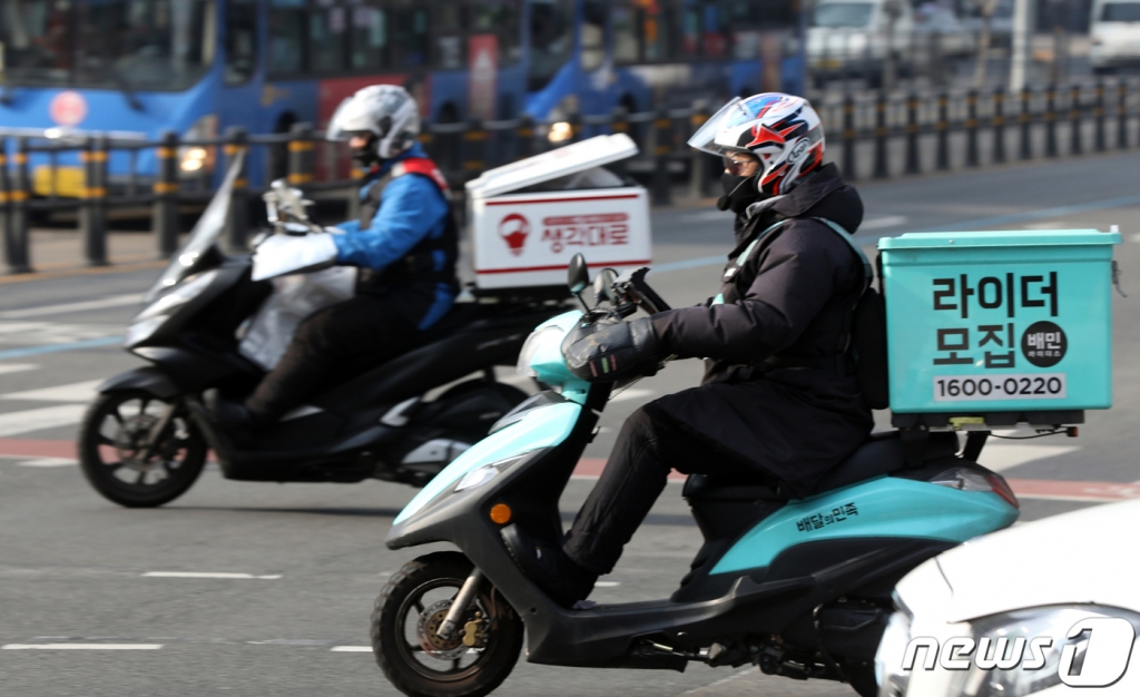(서울=뉴스1) 황기선 기자 = 28일 서울 광화문 사거리에서 음식배달대행 종사자가 도로를 주행하고 있다.  2020.12.28/뉴스1   
