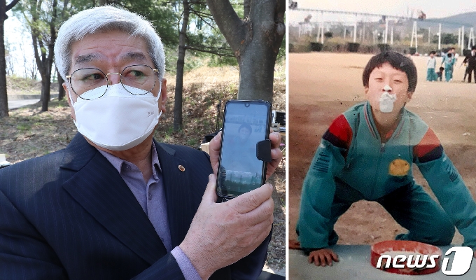 26일 오전 개구리소년 실종사건 30주년을 맞아 대구 달서구 와룡산 선원공원에서 열린 '개구리소년 추모 및 어린이 안전 기원비' 제막식에서 우철원(당시 13세)군의 아버지 우종우씨가 30년을 간직한 아들의 사진을 보여주고 있다. 실종 전 가을운동회에서 밀가루 속 사탕찾기 게임을 마친 아들 철원이가 얼굴에 밀가루를 묻힌 채 해맑게 웃고 있다. 2021.3.26 /뉴스1 © News1 공정식 기자