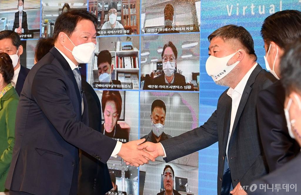 29일 서울 중구 상의회관에서 최태원 신임 대한상공회의소 회장의 취임식을 대신해 열린 '비대면 타운홀 미팅'에서 기념촬영후 김동명 한국노총 위원장과 밝은 표정으로 악수를 나누고 있다./2021. 3. 29 사진공동취재단 /사진=사진공동취재단