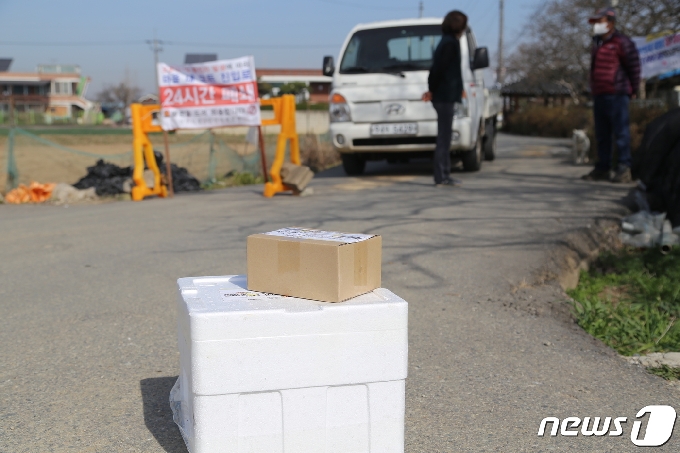 31일 오전 9시30분께 코호트격리 조처가 내려진 전북 전주시 호성동 한사월마을 입구에 택배가 내려져 있다. 마을 주민은 상자를 집어들고 곧바로 집으로 돌아갔다.2021.3.31/© 뉴스1 이지선기자
