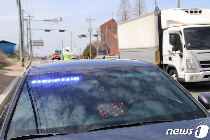 전북경찰청이 새로 도입한 '암행순찰차'인 제네시스 G70  앞 모습. 1일 오후 전북 김제시 백구면 26번 국도 위에서 전북경찰청 암행순찰팀 박명식 경위가 신호위반 차량을 적발하고 사건을 처리하는 동안 파트너 경찰관인 전경노 경장이 능숙하게 다른 차량들을 안전하게 지도하고 있다. 2021.4.1/© 뉴스1 이지선기자