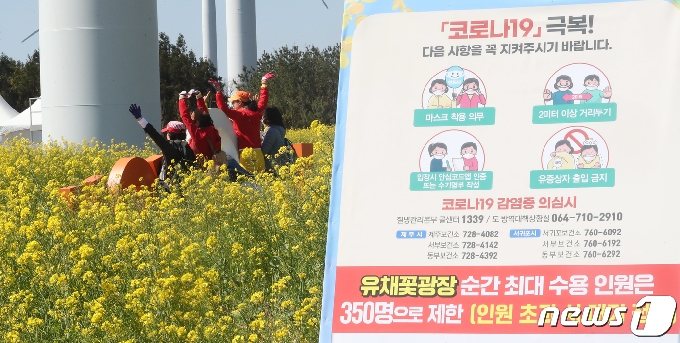 제38회 제주유채꽃축제가 개막한 6일 제주 서귀포시 표선면 가시리 유채꽃광장에서 관광객들이 봄 정취를 즐기고 있다. 서귀포시는 유채꽃광장에 입장할 수 있는 순간 최대 수용인원을 350명으로 제한해 축제를 운영하고 있다.2021.4.6/뉴스1 © News1 오현지 기자