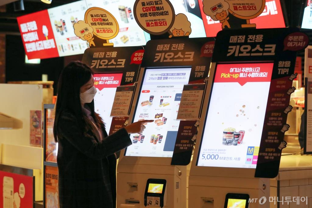 CJ CGV가 대면 서비스를 최소화한 '언택트시네마'를 선보인 가운데 21일 서울 CGV 여의도에서 한 시민이 직원과 대면 없는 매점 키오스크를 이용해 메뉴를 구매하고 있다. '언택트시네마'는 다양한 하이테크 기술을 통해 언택트(Un-tact) 서비스를 기반으로 새롭고 간편하게 극장 시설을 이용할 수 있는 서비스다. /사진=이기범 기자 leekb@