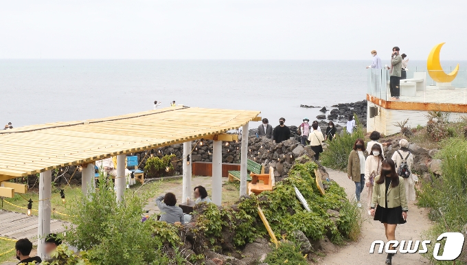 낮 최고기온이 25도까지 오르며 초여름 날씨를 보인 22일 오후 제주시 애월읍 한담해변에서 관광객들이 여유를 만끽하고 있다. 관광객을 중심으로 확산세가 이어지고 있는 제주에서는 이달에만 총 60명의 확진자가 발생했으며, 이중 66%에 달하는 40명이 관광객이거나 다른 지역 확진자와 접촉한 도민, 해외 입국자로 파악됐다.2021.4.22/뉴스1 © News1 오현지 기자