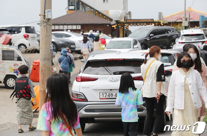 낮 최고기온이 25도까지 오르며 초여름 날씨를 보인 22일 오후 제주시 애월읍 한담해변에 관광객과 렌터카가 몰려 혼잡한 모습을 보이고 있다. 관광객을 중심으로 확산세가 이어지고 있는 제주에서는 이달에만 총 60명의 확진자가 발생했으며, 이중 66%에 달하는 40명이 관광객이거나 다른 지역 확진자와 접촉한 도민, 해외 입국자로 파악됐다.2021.4.22/뉴스1 © News1 오현지 기자