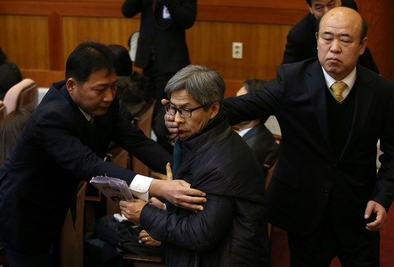 = 19일 오전 서울 종로구 헌법재판소에서 열린 통합진보당에 대한 정당해산심판에서 해산 판결이 나자 권영국 변호사가 법정에서 소리를 질러 쫓겨나고 있다. 2014.12.19/뉴스1  