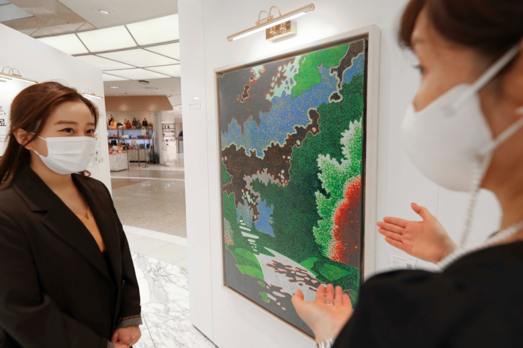 갤러리K 아트딜러가 미술품에 대해 설명하고 있다. 갤러리K는 7월 31일까지 AK플라자 분당점 2층에서 팝업 형식으로 열린다. /사진제공=AK플라자