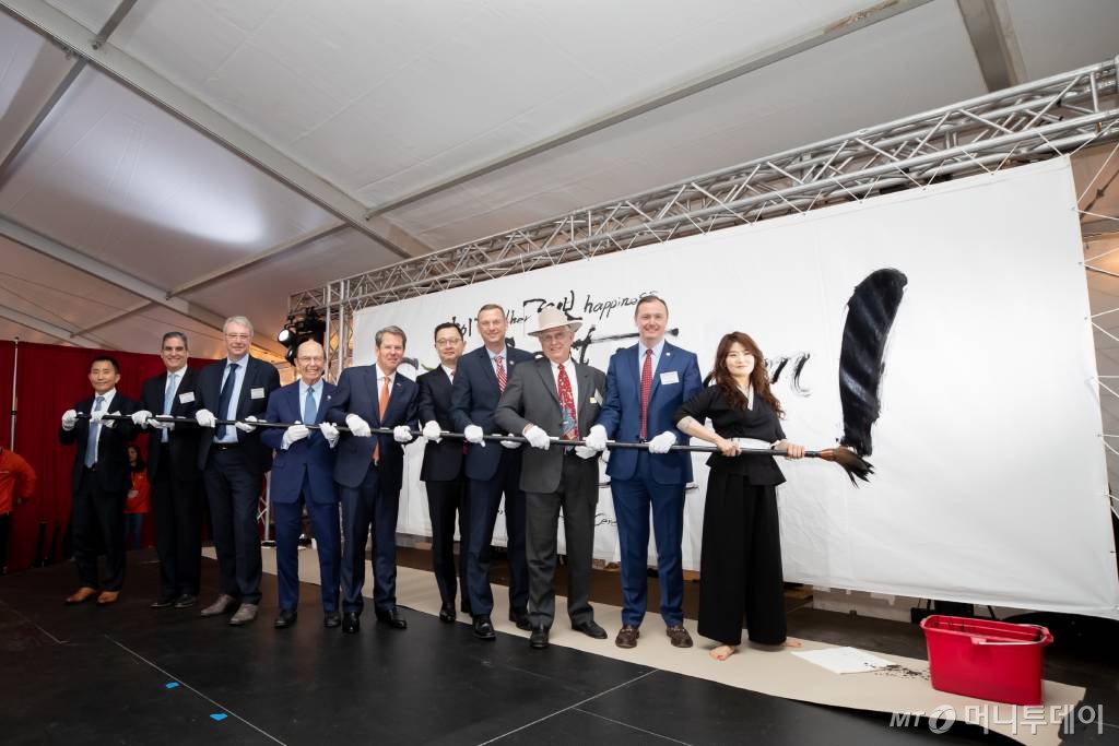 2019년 3월 19일 SK이노베이션 미국 조지아주 자동차 배터리 공장 기공식에서 주요 인사들이 긴 붓으로 느낌표에 화룡정점 하기 전 기념촬영을 하고 있다. 왼쪽부터 윤예선 SK이노베이션 배터리사업대표, 데이브 필립 포드 이사, 스테판 좀머 폭스바겐 이사, 윌버 로스 미국 상무장관, 브라이언 켐프 조지아 주지사, 최재원 SK 수석부회장, 덕 콜린스 미 연방 하원의원, 톰 크로우 잭슨카운티 위원장, 클락 힐 커머스시장. / 사진=SK이노베이션 제공