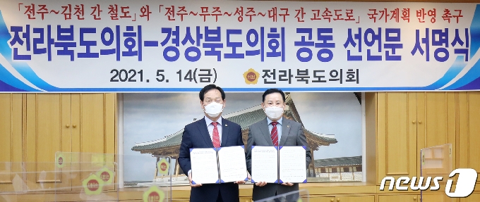 14일 전북 전주시 전북도의회 의장실에서 송지용 전북도의장과 고우현 경상북도의장 등 참석자들이 '전주~김천 간 철도'와 '전주~대구 간 고속도로' 국가계획 반영 촉구 공동 선언문 서명식을 하고 있다. 2021.5.14/뉴스1 © News1 유경석 기자