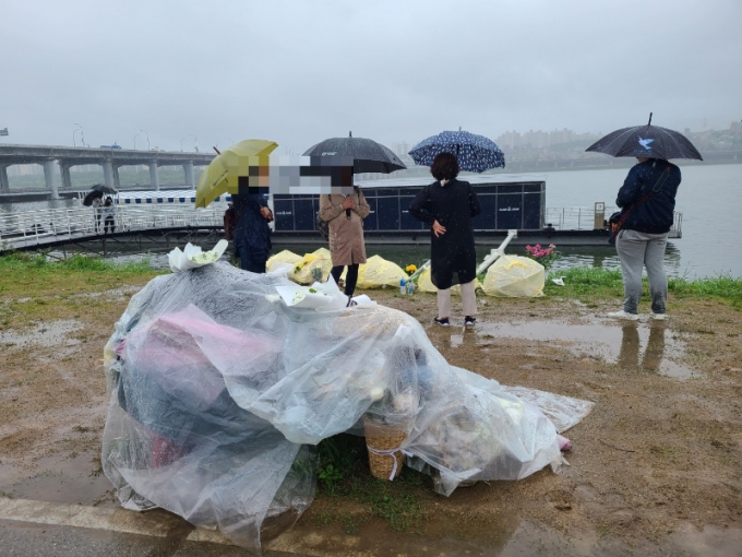 16일 반포 한강공원에서 고 손정민씨를 추모하러 모인 추모객들이 피켓을 들고 있다/사진=임소연 기자