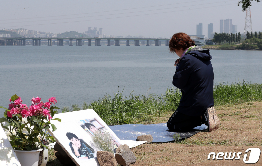 19일 서울 반포한강공원 택시 승강장 인근에 마련된 고 손정민씨 추모 공간을 찾은 한 시민이 무릎을 꿇은 채 기도하고 있다./사진=뉴스1