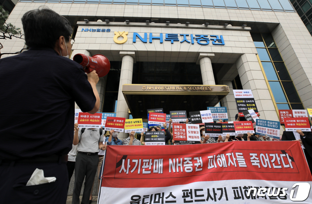 (서울=뉴스1) 구윤성 기자 = 옵티머스 펀드 NH투자증권 피해자들이 23일 오전 서울 여의도 NH투자증권 앞에서 '사기판매'를 규탄하고 있다. 옵티머스펀드의 최대 판매사인 NH투자증권은 이날 이사회를 열고 환매가 중단된 옵티머스자산운용 사모펀드 투자자들에 대한 유동성 공급 방안을 논의할 것으로 알려졌다. 2020.7.23/뉴스1  