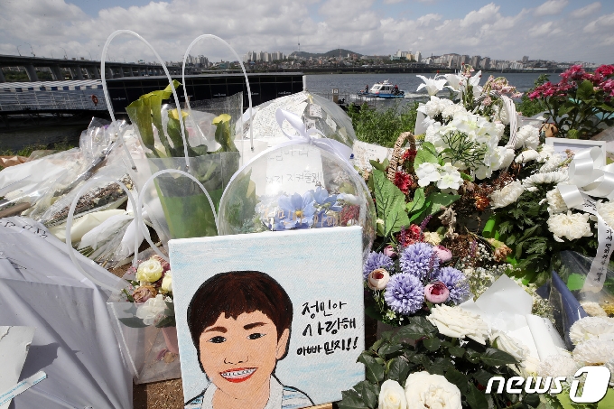 故 손정민씨가 한강공원에서 실종됐다가 숨진 채 발견된 지 한 달째 되는 25일 오후 서울 서초구 반포수상택시 승강장 인근에 마련된 추모공간 너머로 수색작업이 계속되고 있다. 2021.5.25/뉴스1 © News1 조태형 기자