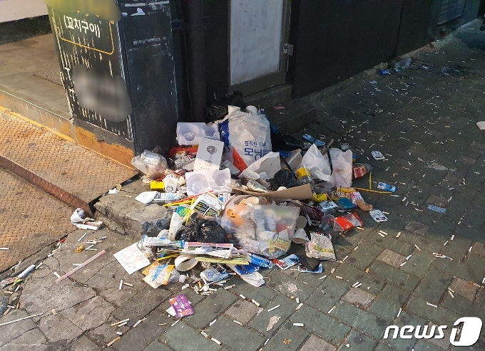 '영업시간 제한 해제' 및 '9인 이상 사적모임 금지'가 시행된 첫 주말인 26일 부산 부산진구 서면 거리 구석에 담배꽁초와 각종 쓰레기가 쌓여있다© 뉴스1