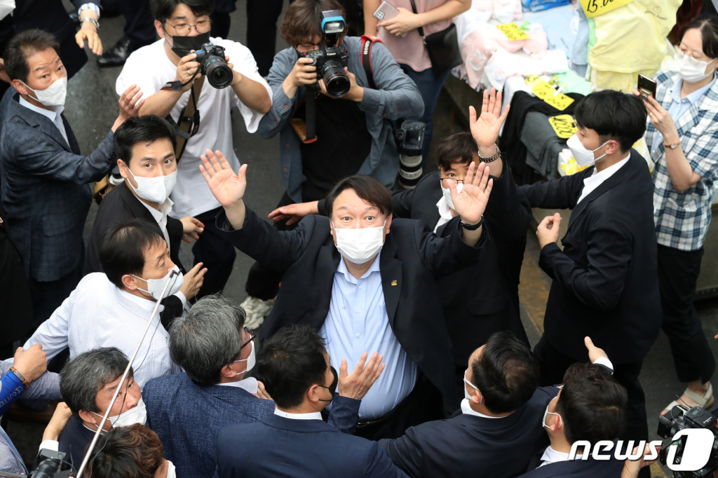 (대구=뉴스1) 공정식 기자 = 야권 대선주자인 윤석열 전 검찰총장이 20일 낮 대구 서문시장을 찾아 상가 연결통로에 환영 나온 시민들을 향해 손을 흔들어 인사하고 있다. 2021.7.20/뉴스1  