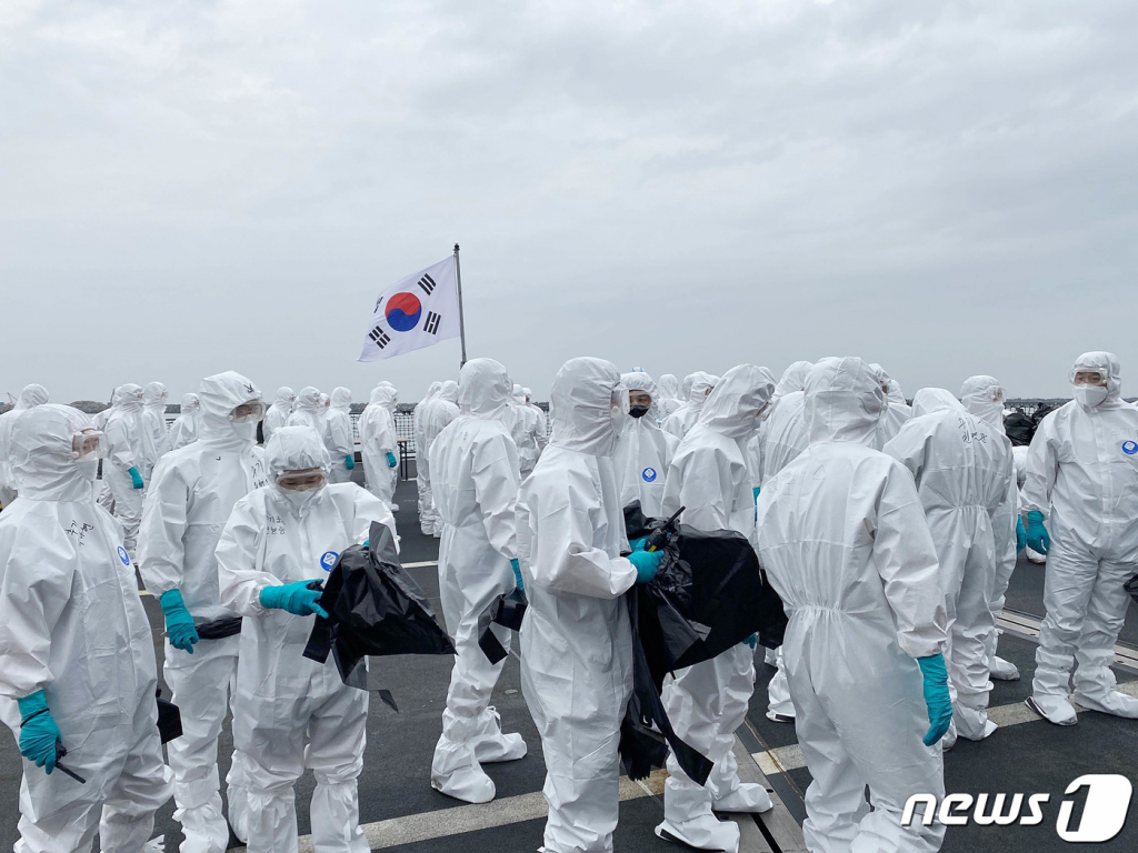 (서울=뉴스1) = 코로나19 집단감염이 발생한 청해부대 34진을 국내로 이송하기 위해 출국한 특수임무단이 19일(현지시간) 아프리카 해역에서 문무대왕함에 승선해 방역작업을 준비하고 있다. (국방부 제공) 2021.7.19/뉴스1  