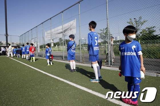 성동축구클럽 소속 어린이들이 5월 6일 오후 서울 성동구 응봉체육공원 축구장에서 체온체크와 손소독을 위해 줄 서 있다. / 사진 = 뉴스1