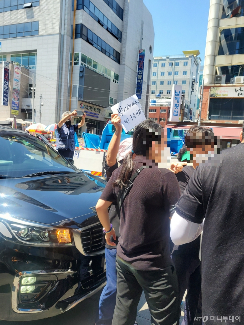 한 40대 여성이 자갈치 시장 입구에서 "박근혜 전 대통령을 왜? 구속시켰나"라고 적힌 손팻말을 들고 윤 전 총장에게 항의하고 있다./사진=안채원 기자