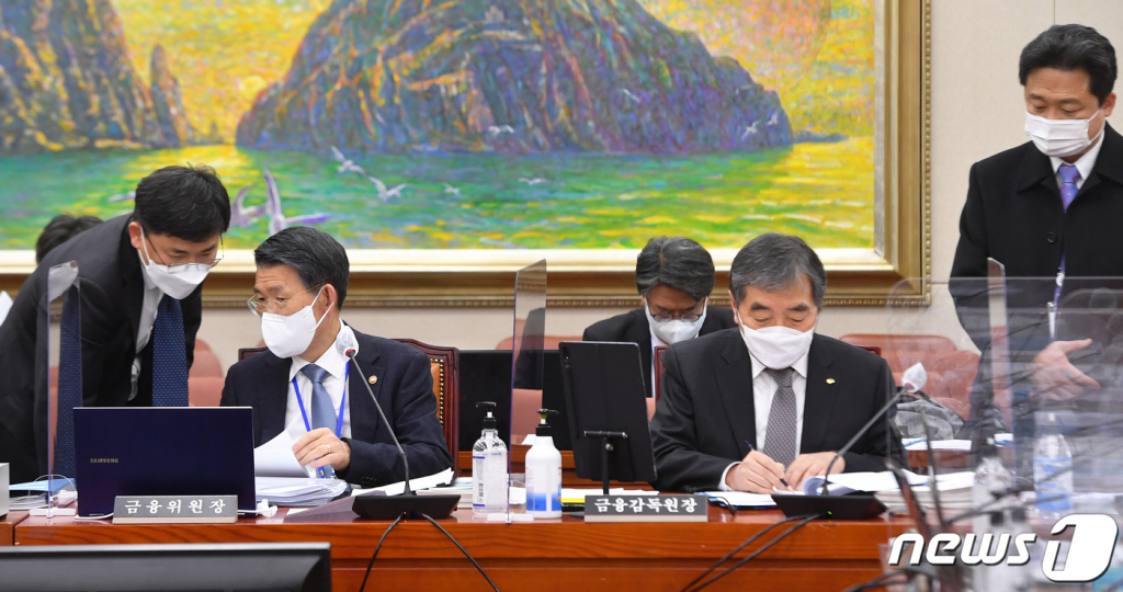(서울=뉴스1) 성동훈 기자 = 은성수 금융위원장과 윤석헌 금융감독원장이 17일 오후 서울 여의도 국회에서 정무위원회 전체회의를 기다리며 자료를 보고 있다. 2021.2.17/뉴스1  