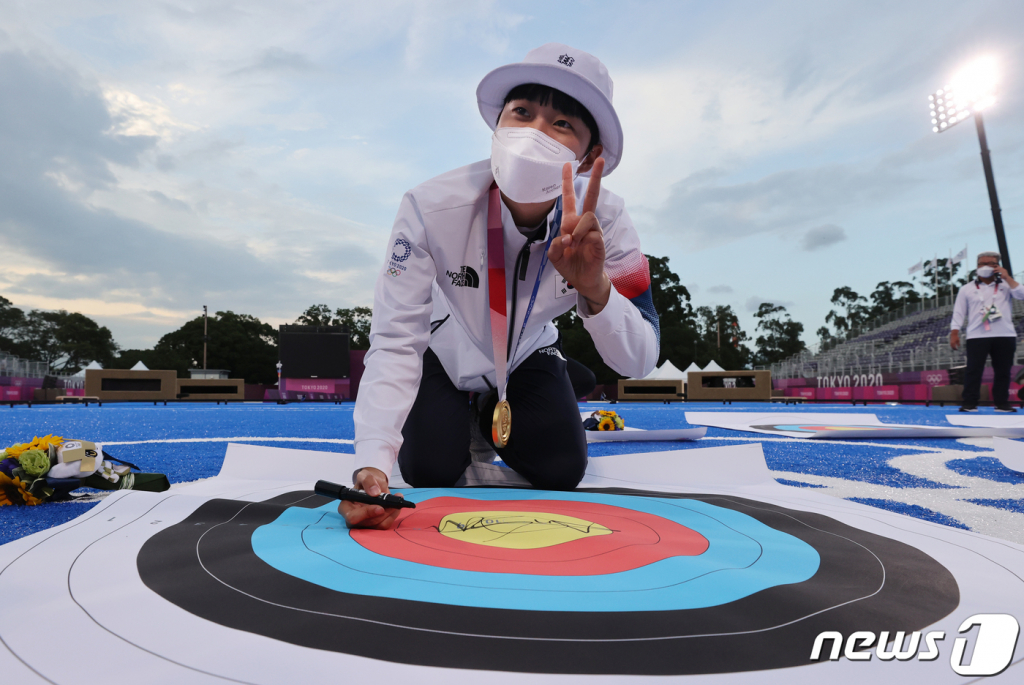 (도쿄=뉴스1) 송원영 기자 = 양궁 안산이 30일 일본 도쿄 유메노시마 공원 양궁장에서 열린 '2020 도쿄올림픽' 여자 개인전 시상식을 마치고 과녁판에 사인을 하고 있다. 2021.7.30/뉴스1