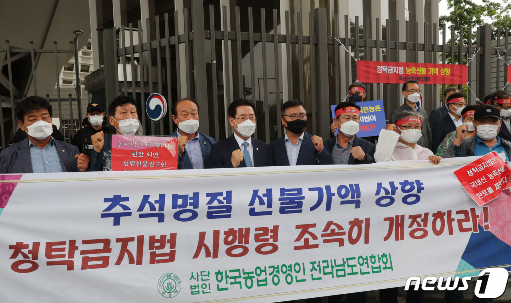 (무안=뉴스1) 전원 기자 = 김영록 전라남도지사가 23일 정부세종청사 앞에서 열린 청탁금지법 국내산 농축산물 선물가액 상향 촉구 한국농축산연합회·축산관련단체협의회 공동기자회견장을 방문해 한국농업경영인 전라남도회원들과 '추석 명절기간 청탁금지법 상 농수산물 선물가액을 10만 원에서 20만 원으로 한시적 한도상향'을 정부에 촉구 하고 있다.(전남도 제공) 2021.8.23/뉴스1   