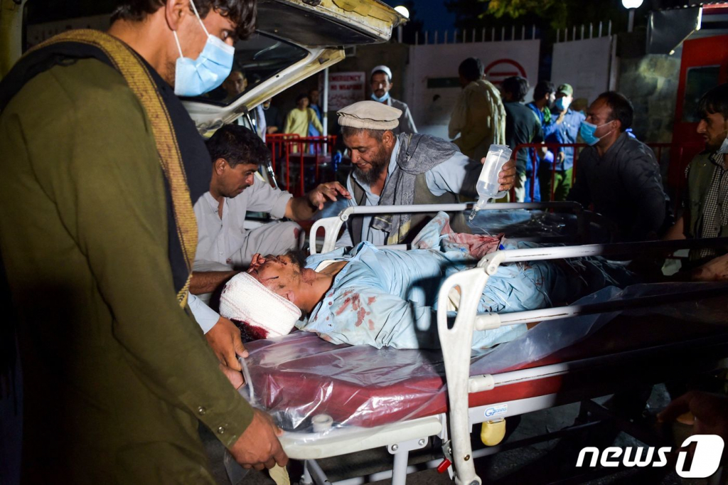 (AFP=뉴스1) = 아프가니스탄의 수도 카불 공항 인근에서 26일(현지시간) 연쇄 자살폭탄 테러가 발생해 부상자가 이송돼고 있다. 외신은 두번의 폭발로 현재까지 90명이 사망하고 150명이 부상당했다고 밝혔으며 이슬람 무장조직인 IS는 자신들이 공격 주체라고 밝혔다. 2021.8.27/AFP=뉴스1   