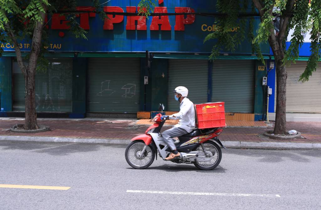  [붕따우=AP/뉴시스] 19일 베트남 붕따우에서 한 배달원이 스쿠터를 타고 코로나19 봉쇄로 문 닫은 상점가를 지나고 있다. 4천만 명에 가까운 인구를 가진 남부 베트남은 코로나19의 기록적인 증가로 2주간 봉쇄에 들어갔다. 2021.07.19.