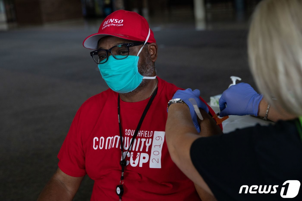 (사우스필드 AFP=뉴스1) 우동명 기자 = 24일 (현지시간) 미시간주 사우스필드에 있는 코로나19 백신 접종소에서 주민이 모더나 백신 부스터샷을 맞고 있다.  ? AFP=뉴스1  