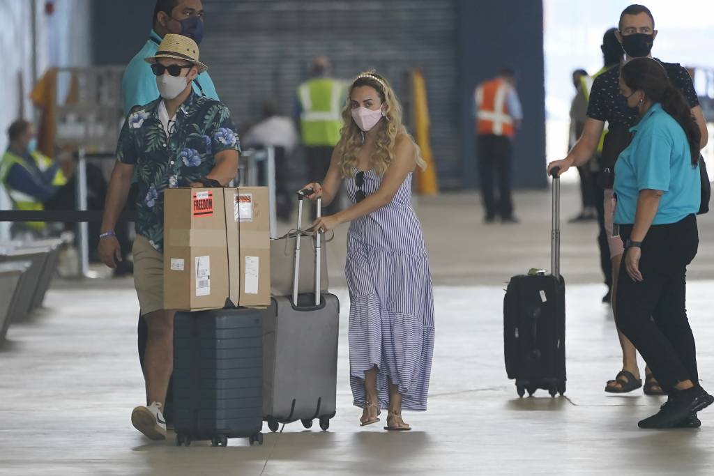 [마이애미=AP/뉴시스]20일(현지시간) 미 플로리다주 마이애미의 마이애미 항구에 로열 캐리비안 직원들이 모의 유람을 앞둔 '프리덤 오브 더 시즈'(Freedom of the Seas) 유람선 승선을 위해 도착하고 있다. 이 선사는 코로나19로 15개월간 중단됐던 운항 재개를 위해 코로나19 방역 안전 규정을 구현하고 있다. 미국 질병통제예방센터(CDC)는 지난달 크루즈 라인 승무원의 98%와 손님의 95%가 예방 접종을 마친 경우 선박의 재운항을 승인했다. 2021.06.21.