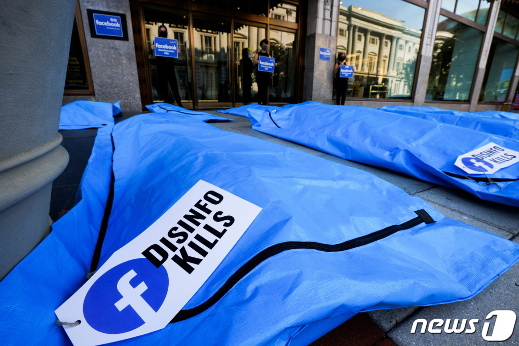 (워싱턴 로이터=뉴스1) 이정후 기자 = 28일(현지시간) 미국 워싱턴 페이스북 지사 앞에서 코로나19 허위 정보를 규제하지 않는 페이스북에 항의하기 위해 시위대가 시체 가방을 전시하고 있다.  ? 로이터=뉴스1  