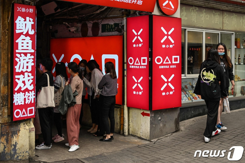 12일(현지시간) 중국 상하이에서 넷플릭스 드라마 ‘오징어 게임’을 테마로 한 달고나 가게서 손님들이 입장을 기다리고 있다.  /사진=뉴스1  