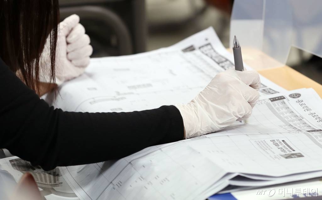 4일 오후 서울 종로학원 강남본원에서 온라인 생중계 방식으로 열린 '수능 직후, 2021 대입전략 설명회'를 찾은 학부모들이 배치참고표를 살펴보고 있다. /사진=김휘선 기자 hwijpg@