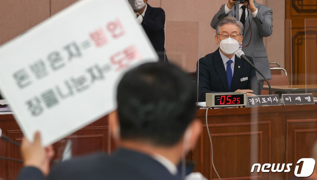 이재명 경기도지사가 20일 경기도 수원시 팔달구 경기도청에서 열린 국회 국토교통위원회의 경기도에 대한 국정감사에서 대장동 관련 피켓을 든 박성민 국민의힘 의원을 바라보고 있다. /사진=뉴스1
