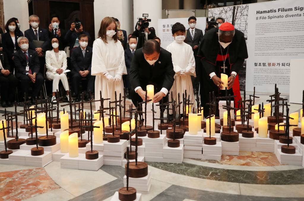[로마=뉴시스] 김진아 기자 = 문재인 대통령이 29일(현지시간) 이탈리아 로마 산티냐시오 디 로욜라 성당에서 열린 ‘철조망 평화가 되다’ 전시회에서 피터 턱슨 추기경과 한반도를 형상화한 전시작품의 LED 촛불 점등식을 하고 있다. 2021.10.29.