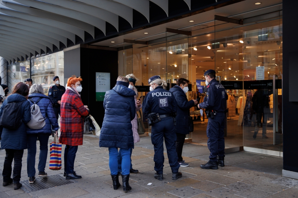 Police officers check the vaccination status of shoppers at the entrance of a store after the Austrian government imposed a lockdown on roughly two million people who are not fully vaccinated against the coronavirus disease (COVID-19) in Vienna, Austria, November 16, 2021. REUTERS/Lisi Niesner Date: 16/11/2021 09:18
