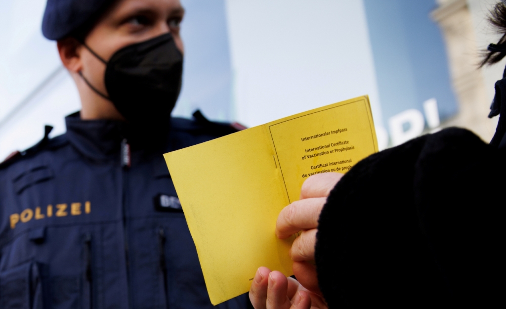  A police officer checks the vaccination status of a shopper at the entrance of a store after the Austrian government imposed a lockdown on the roughly two million people who are not fully vaccinated against the coronavirus disease (COVID-19) in Vienna, Austria, November 16, 2021. REUTERS/Lisi Niesner/File Photo