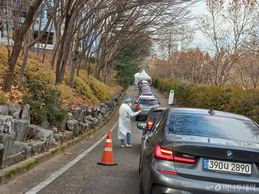 지난 9일 오전 10시 45분 1시간 45분 대기 후 드라이브 스루 검사소 입구에 도착했다. 입구에서 천막까지는 22대의 차량이 대기중이다. 방역복을 입은 보건소 직원들이 검사 설문지를 걷어가고 있다. / 사진=양윤우 기자 