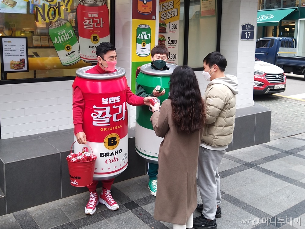 송현석 신세계푸드 대표이사와 이대희 수원호매실점 가맹점주가 14일 특별 제작한 콜라맨, 사이다맨 의상을 착용한 채 노브랜드 버거 서울시청점 앞에 깜짝 등장하기도 했다. /사진=구단비 기자