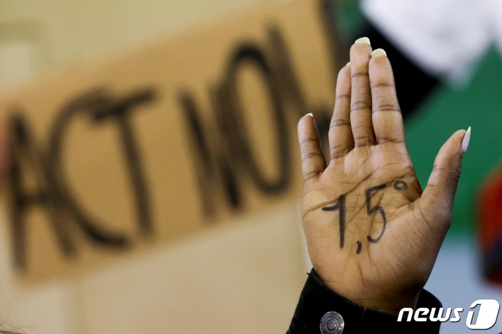 (글래스고 로이터=뉴스1) 우동명 기자 =  10일(현지시간) 영국 글래스고에서 열린 제26차 유엔기후변화협약 당사국회의(COP26)서 시위대가 '1.5도'라고 쓴 손바닥을 들어 보이며 기후 위기 대응책을 요구하는 시위를 하고 있다.   ? 로이터=뉴스1  