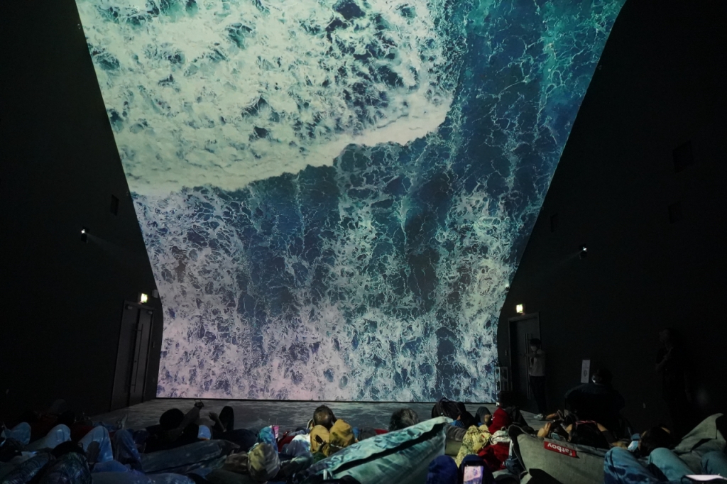 2030 두바이 월드엑스포 한국관을 찾은 방문객들이 수직으로 설계해 압도적인 몰입감을 선사하는 '버티컬 씨네마'로 한류 콘텐츠를 감상하고 있다./사진제공=2030 두바이 월드엑스포 한국관