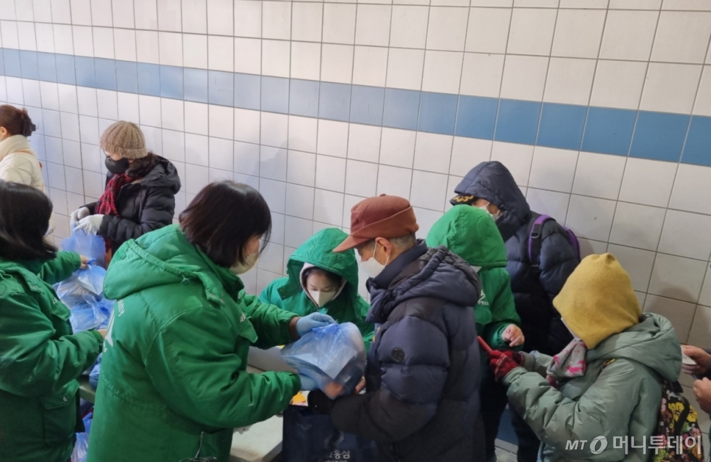 17일 서울시 동대문구 밥퍼나눔운동본부 옆 답십리 굴다리에서 본부 관계자가 무료 급식을 배급하고 있다. /사진=조성준 기자