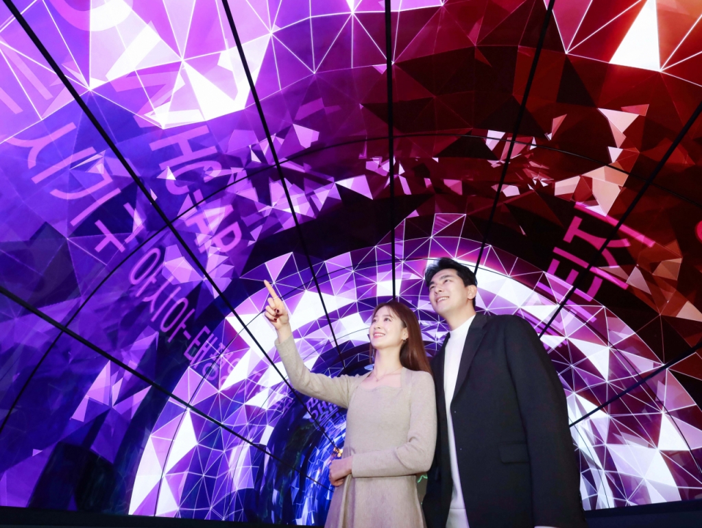  LG전자가 경주 소재 세계유산 미디어 홍보관인 '살롱 헤리티지(Salon Heritage)'에 올레드 플렉서블 사이니지, 투명 올레드 사이니지, LED 사이니지 등을 설치했다. 모델들이 55형 올레드 플렉서블 사이니지 72장으로 조성한 10m 길이 올레드 터널에서 미디어 아트를 감상하고 있다./사진제공=LG전자