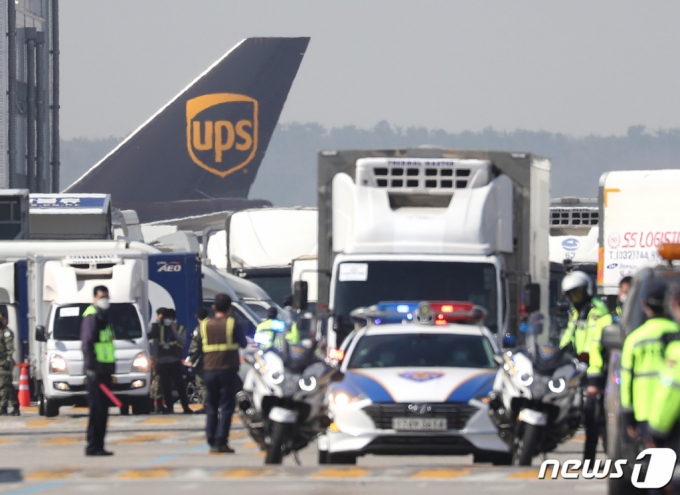 (인천공항=뉴스1) 이성철 기자 = 31일 오전 인천국제공항 화물터미널에서 UPS 항공기 앞으로 화이자의 신종코로나바이러스 감염증(코로나19) 백신 50만회분(25만명분)을 실은 백신수송차량이 중앙 및 권역예방접종센터로접종센터로 향하고 있다. UPS 항공기로 도착한 이번 화이자 백신은 49개소 접종센터로 옮겨져 다음 달 1일 시작되는 75세 이상 어르신 접종에 사용된다. 2021.3.31/뉴스1